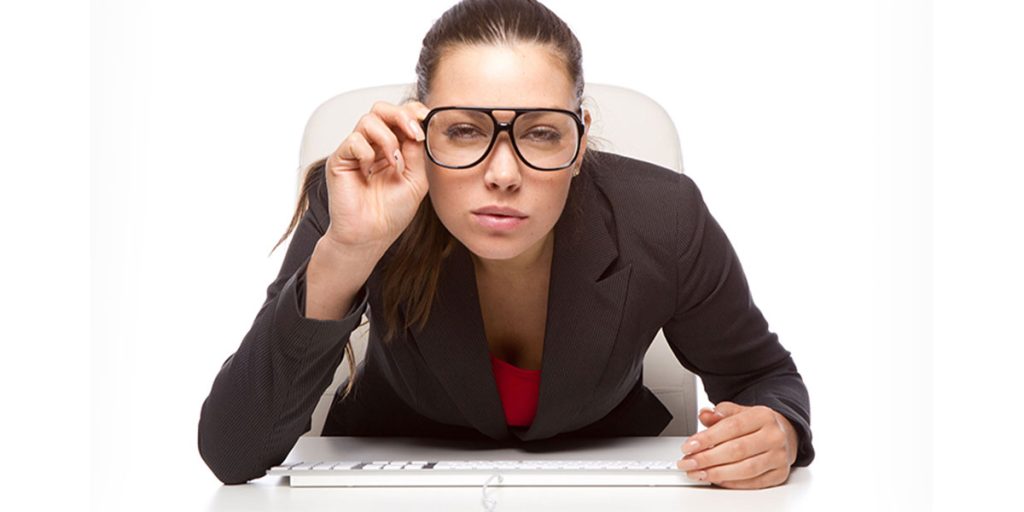 Girl adjusting her glasses to view her pc screen