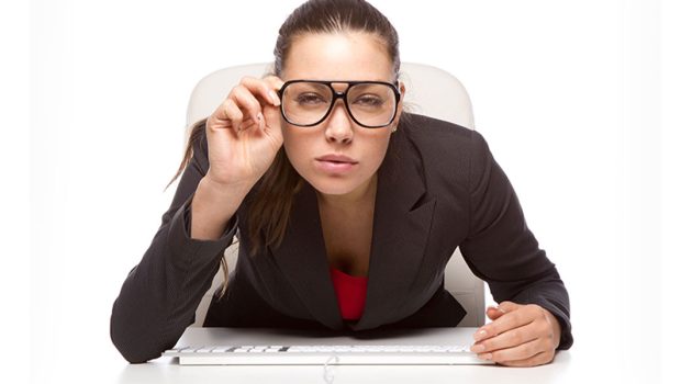 Girl adjusting her glasses to view her pc screen