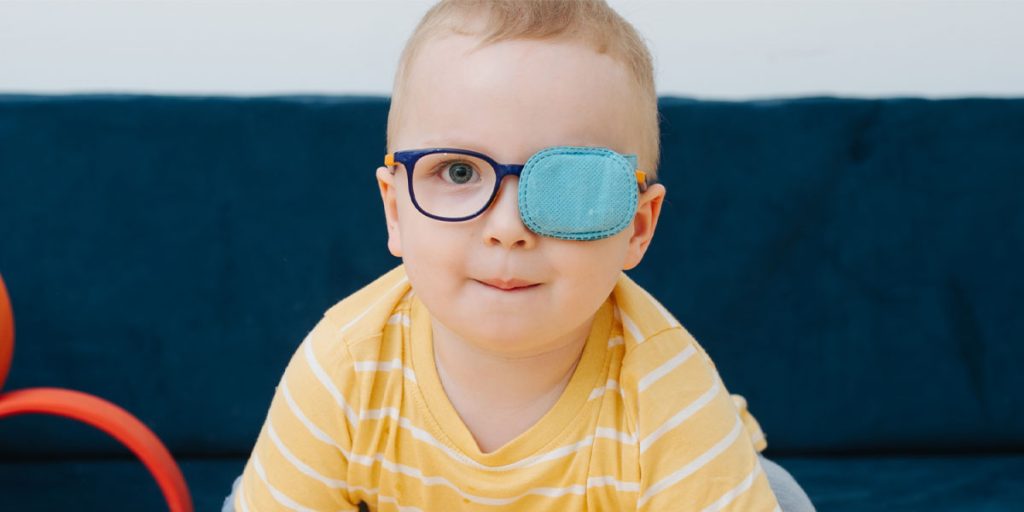 Baby with an eye patch and glasses